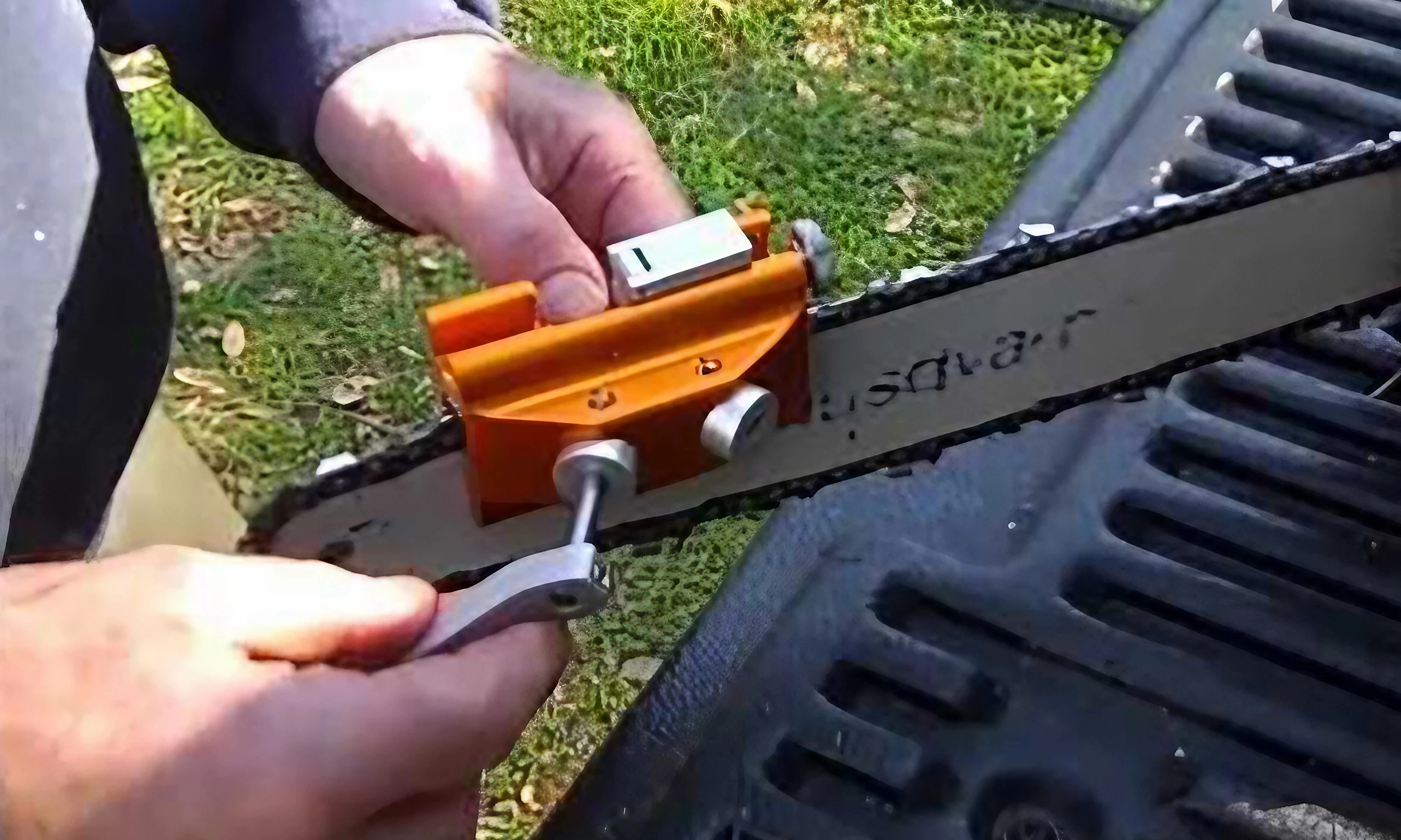 Sharpening a chainsaw chain on the bar with a portable sharpener outdoors